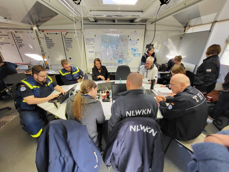 Lagebesprechung der Lenkungsgruppe am Standort Norden mit Vertretern vom NLWKN, der Landkreise Aurich und Leer sowie der Stadt Emden in der großen mobilen Führungsstelle des Fachzug Führung und Kommunikation des THW (Foto: NLWKN)